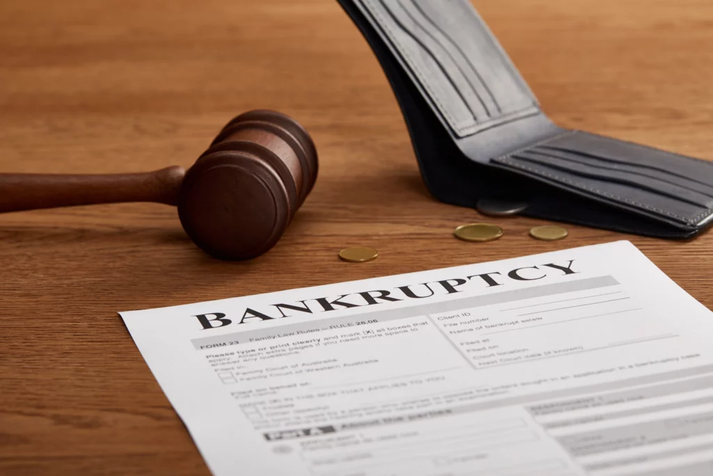 Bankruptcy paperwork with judge’s gavel, open wallet, and coins on wooden table representing financial evaluation and asset liquidation in Chapter 7 bankruptcy.